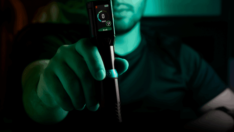 Mão de tatuador segurando uma máquina de tatuagem Electric Ink moderna, representando o serviço de assinatura Electric Ink Sempre.