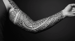 Braço com uma tatuagem blackwork, misturando estilos tribal e geométrico com preenchimento preto sólido.