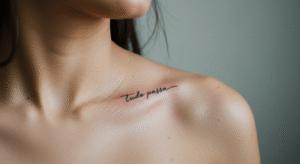 Tatuagem na clavícula com a frase "Tudo Passa" em caligrafia fina, ilustrando seu significado de resiliência.